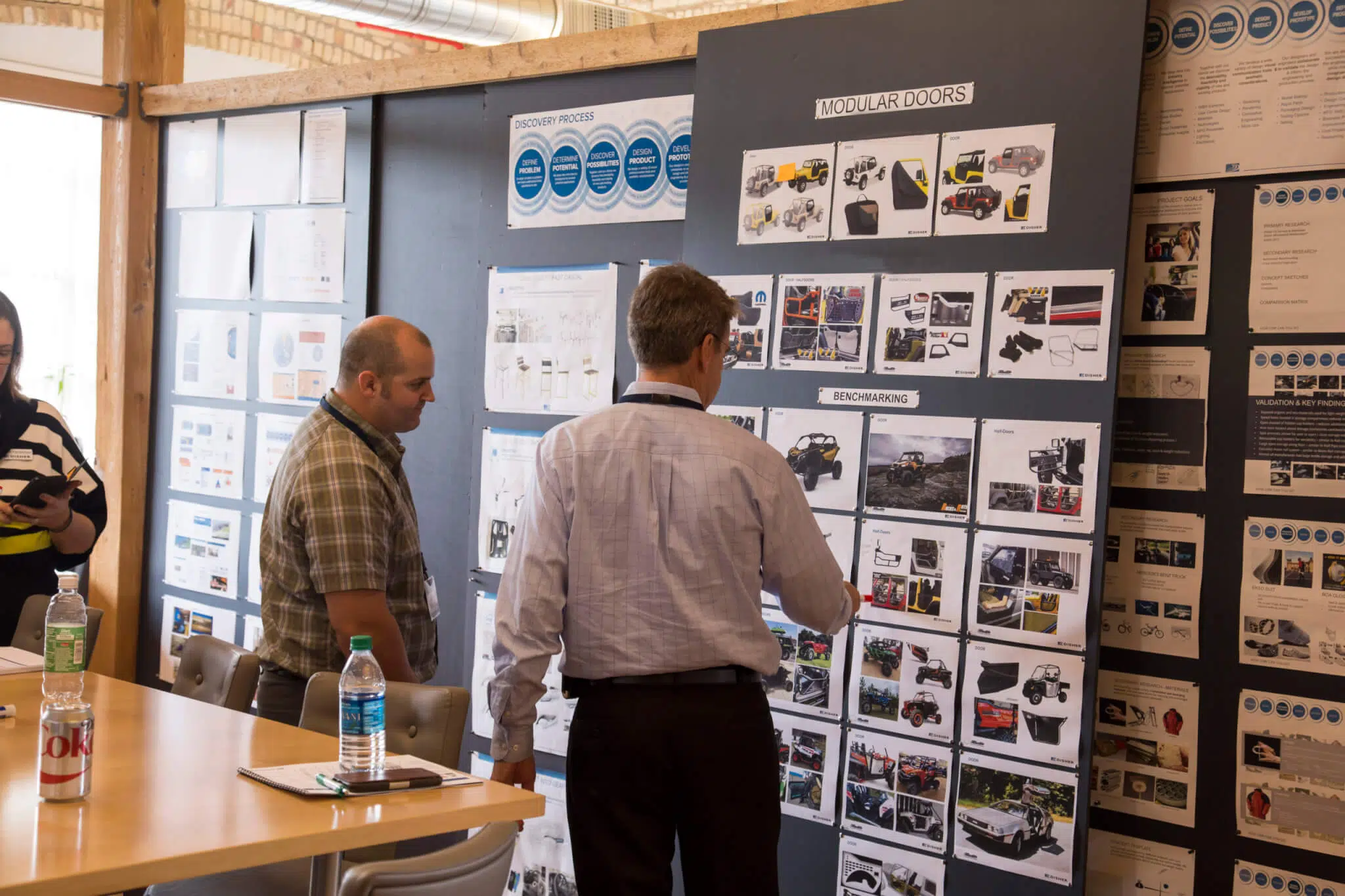 Two men looking a benchmarking idea boards