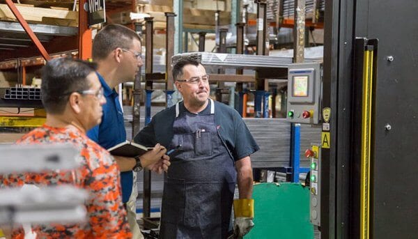 An engineer talks with a worker in a manufacturing space