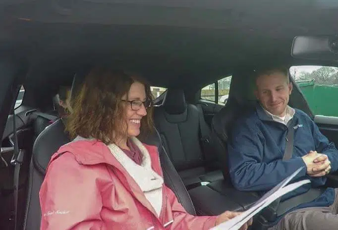 Women interviewing a man in a car