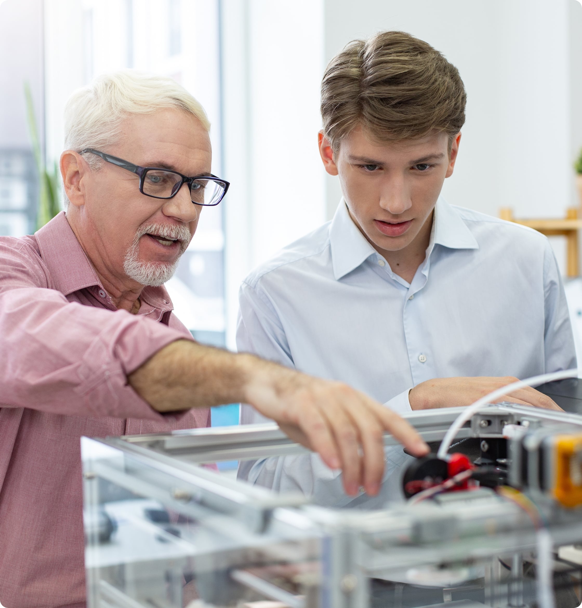 A older man showing a younger engineer a 3D printer