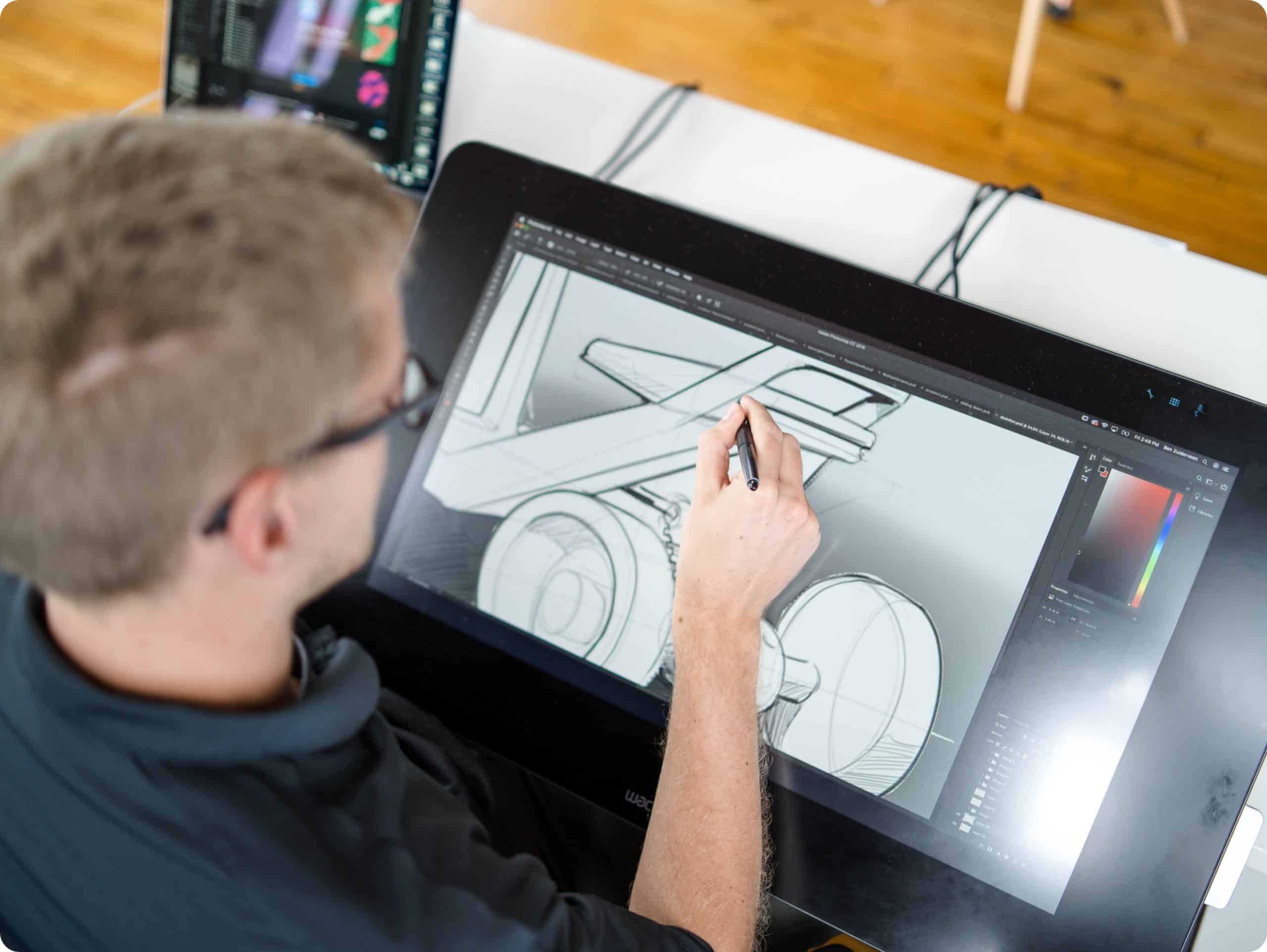 An industrial designer sketching on a digital tablet