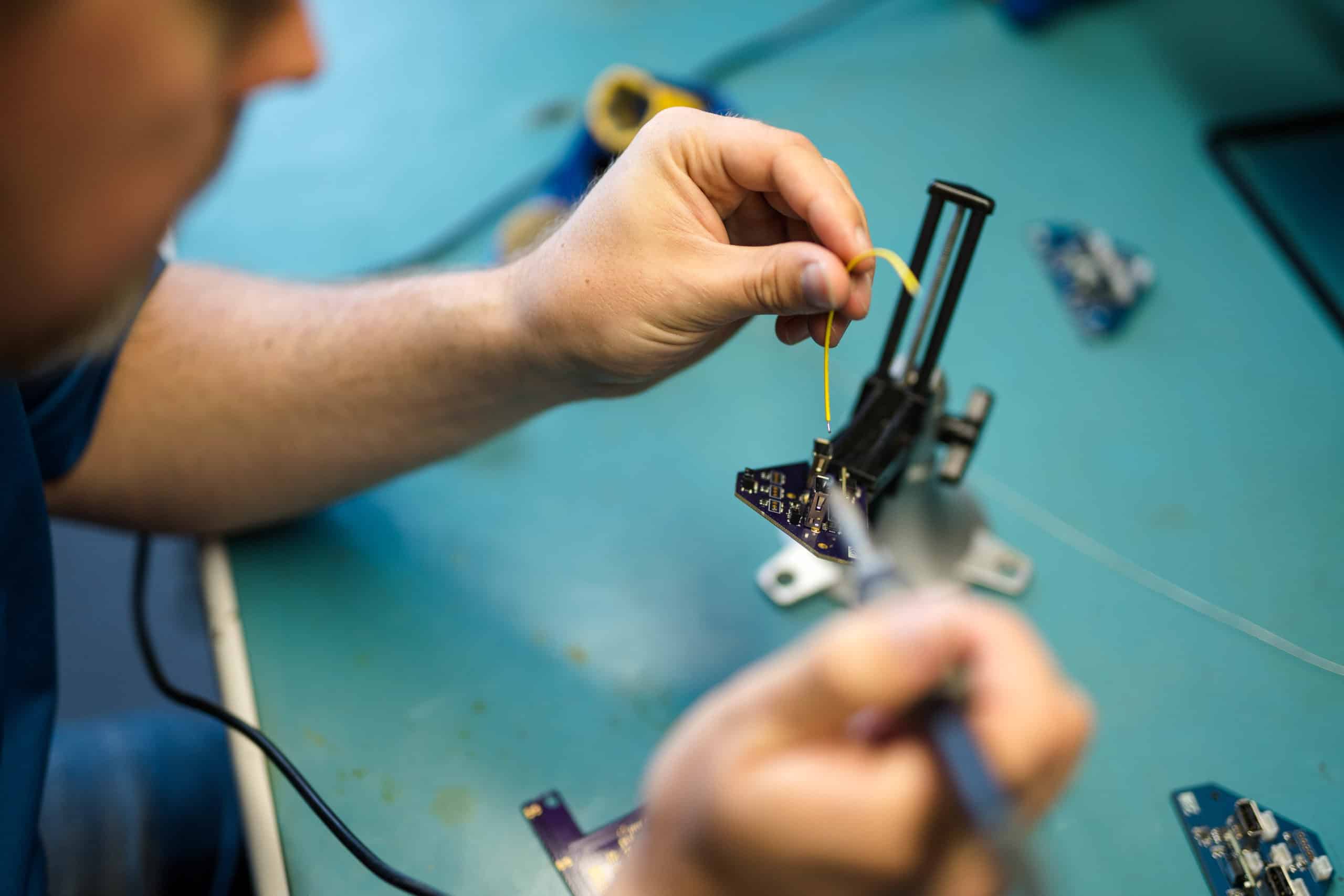 An electronics engineer soldering a PCB board