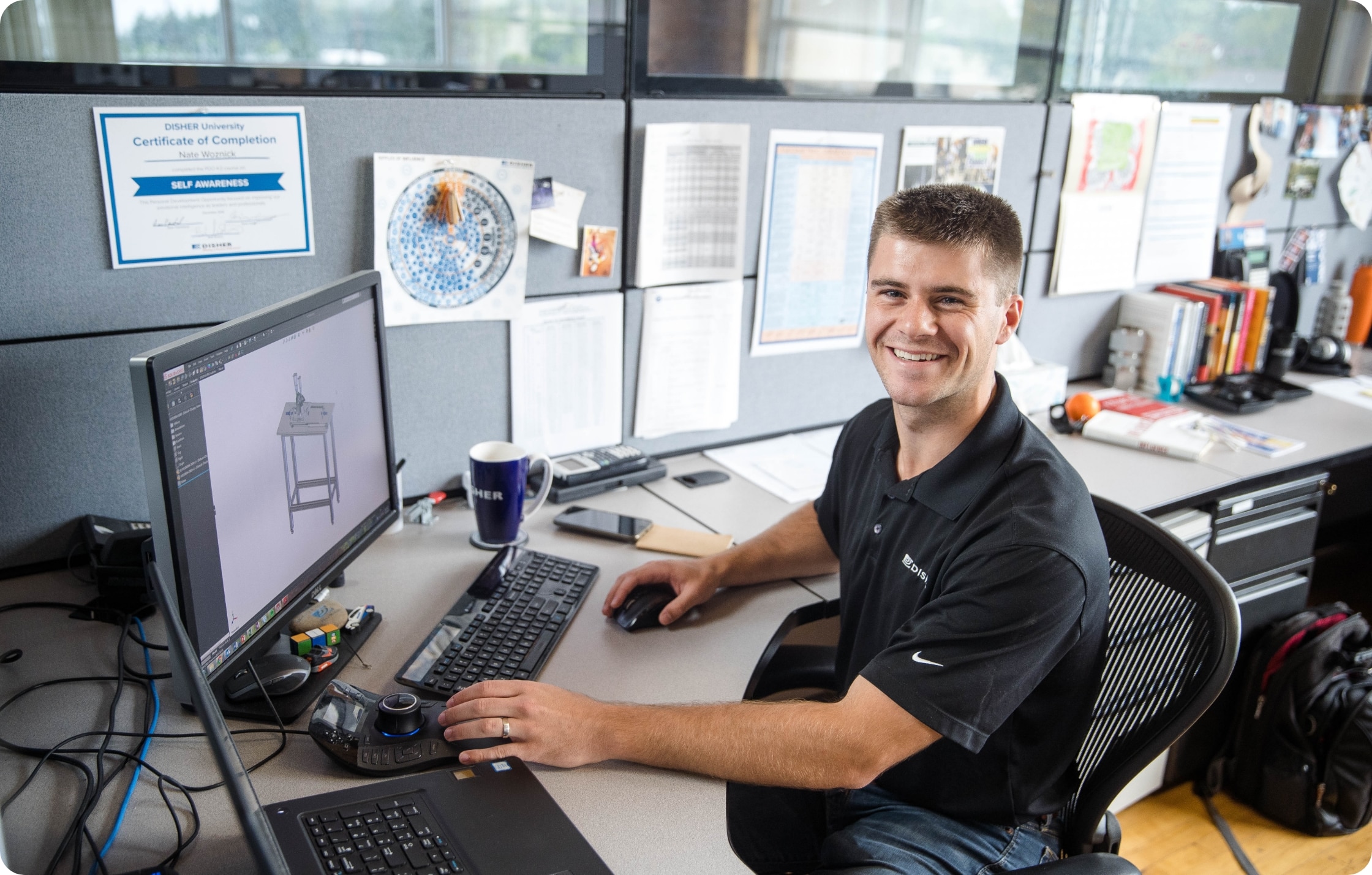 A male engineer smiling at desk