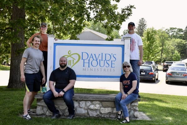 Volunteers posing in front of the Davids House sign