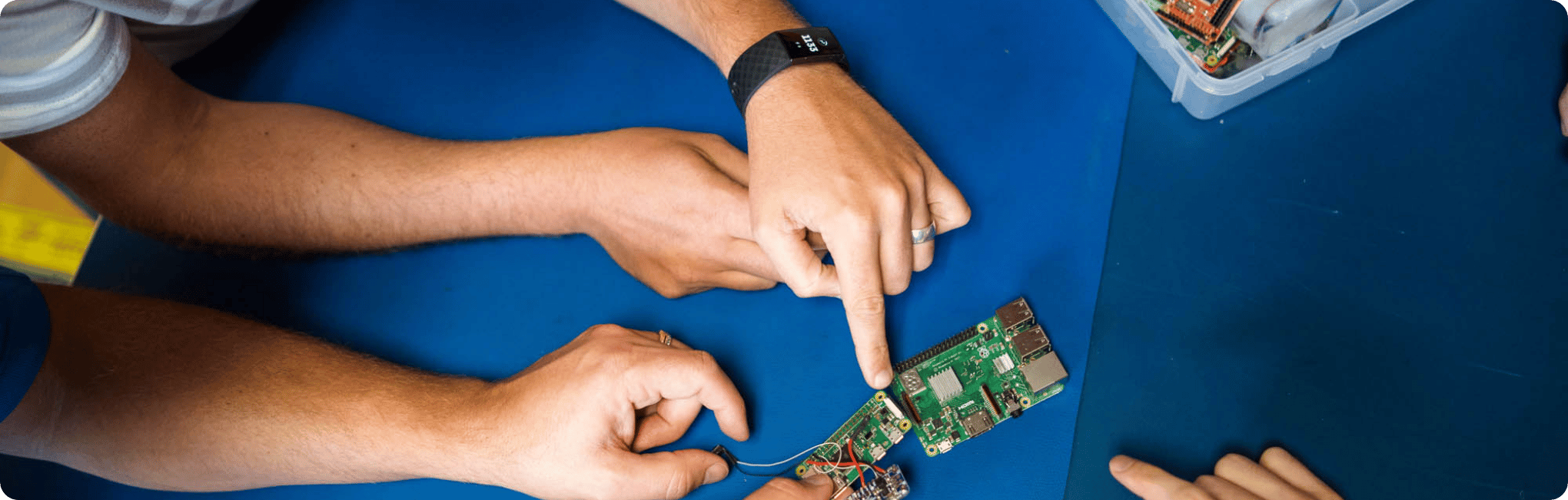 Engineers pointing at a PCB board