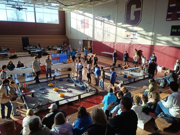 a group of people at a robotics event in a gym