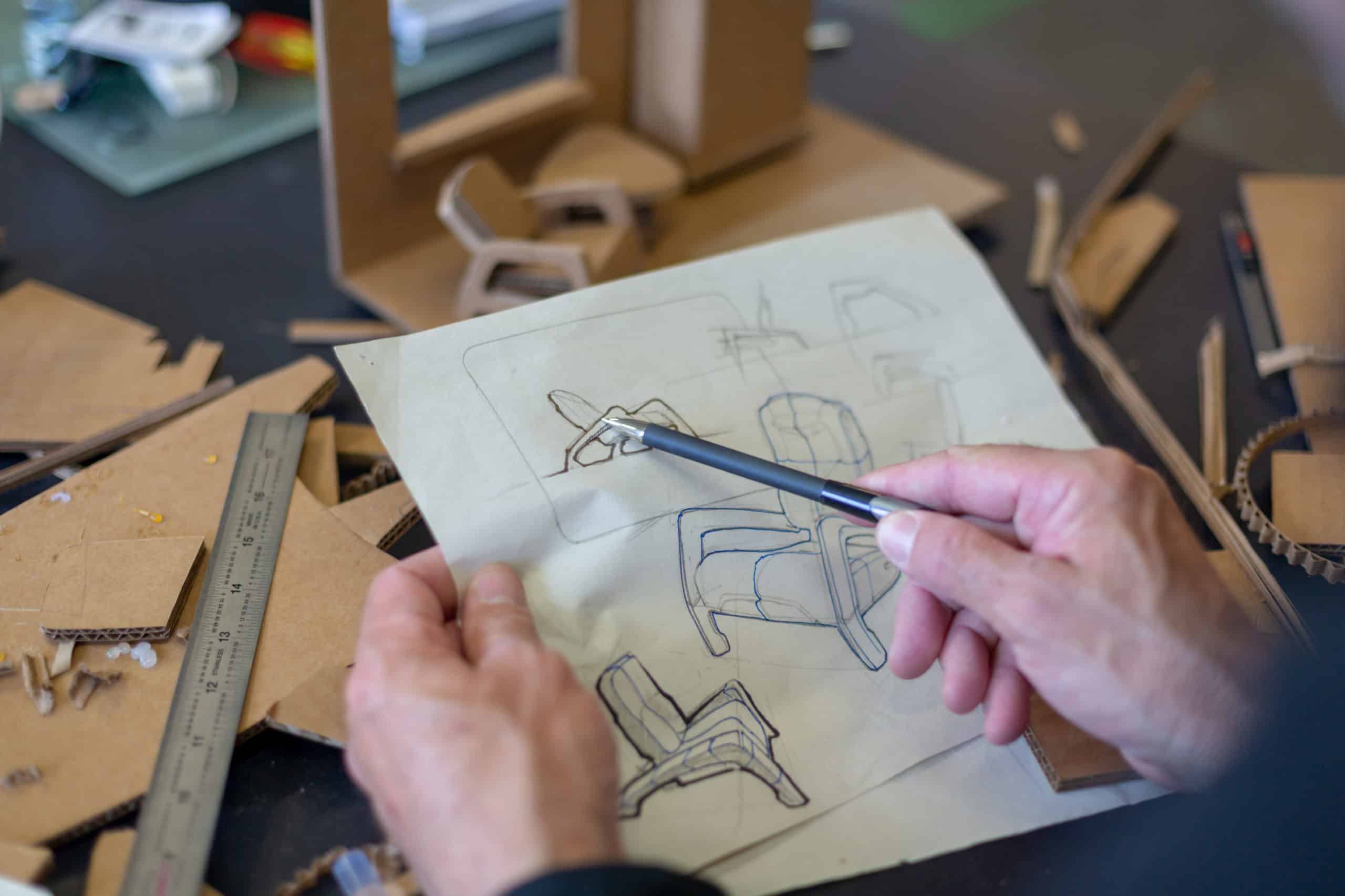 Industrial designer doing rapid prototypingpointing to a sketch of furniture