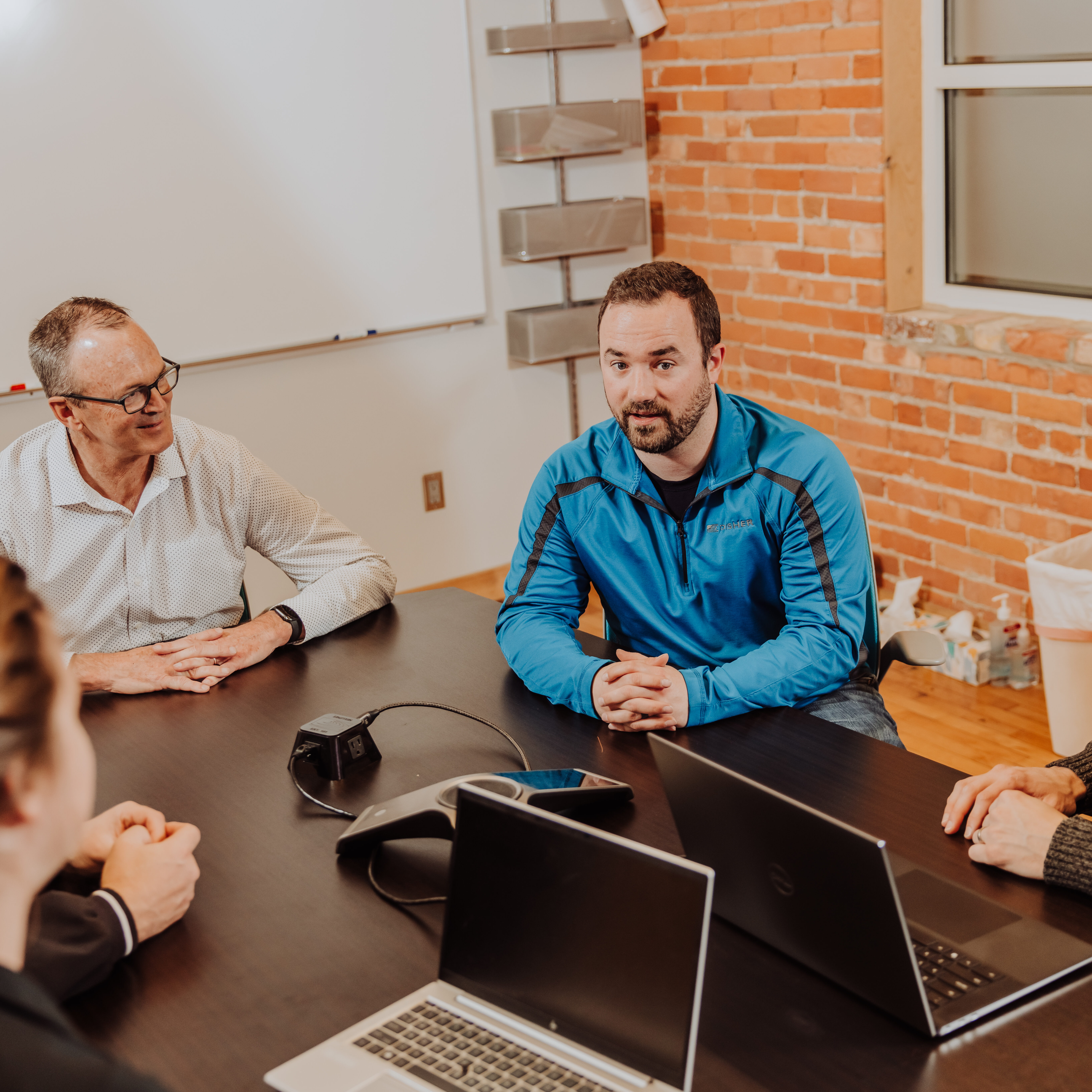 Engineers sit around a table discussing a project with a customer