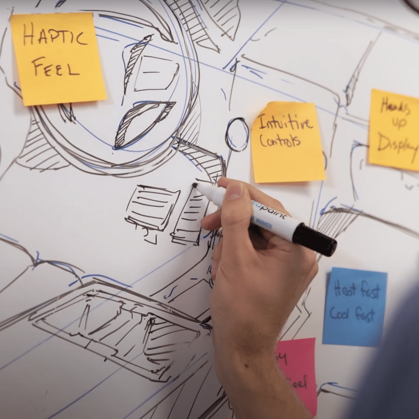 Industrial designer drawing on a whiteboard