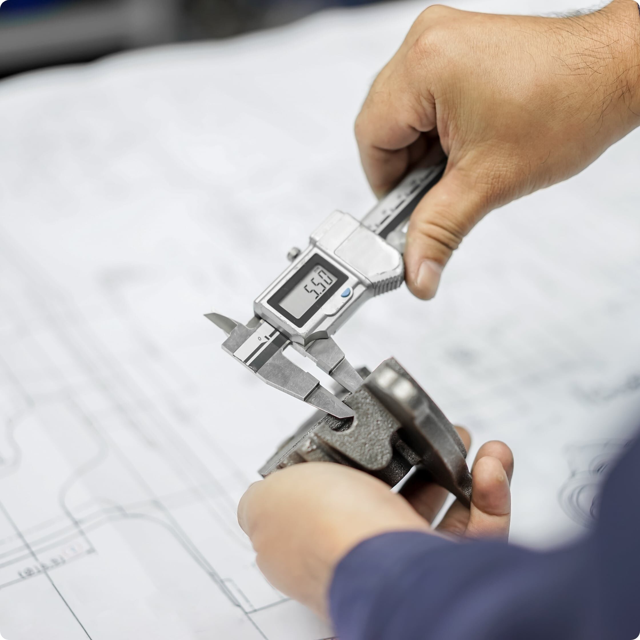 A man using calipers to measure a part