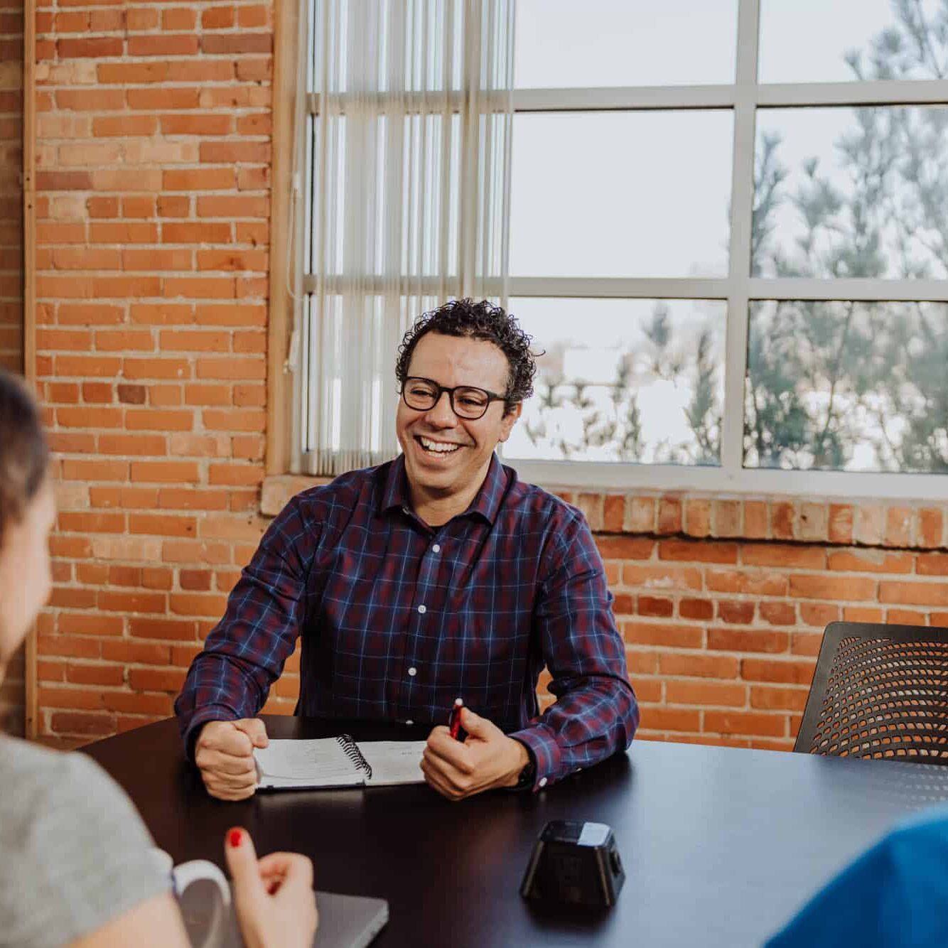 A man smiling while he is being interviewed for a job