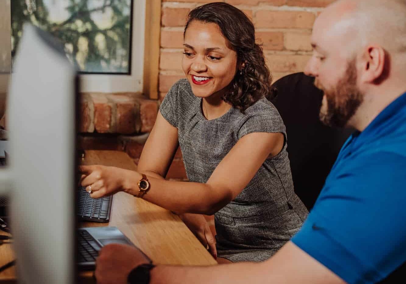 Two talent recruiters looking at a computer discussing talent brand