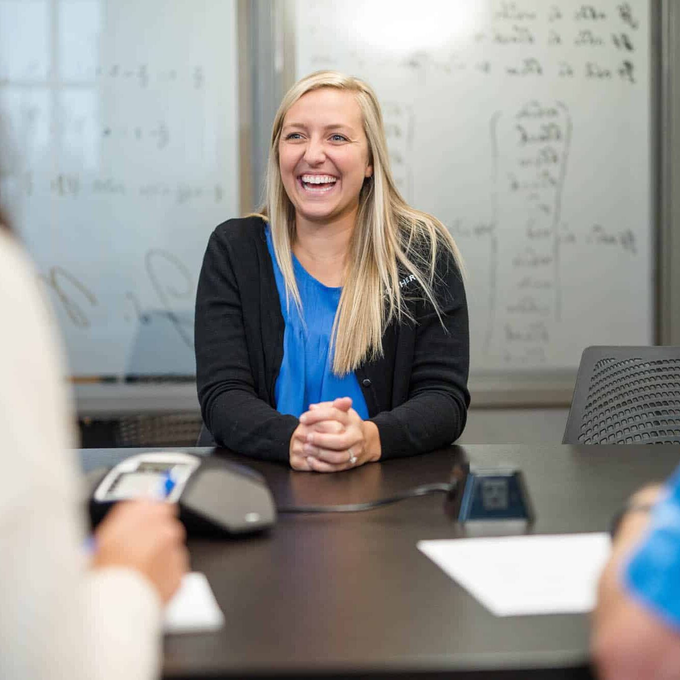 Women smiling while at a table being interviewed for a job