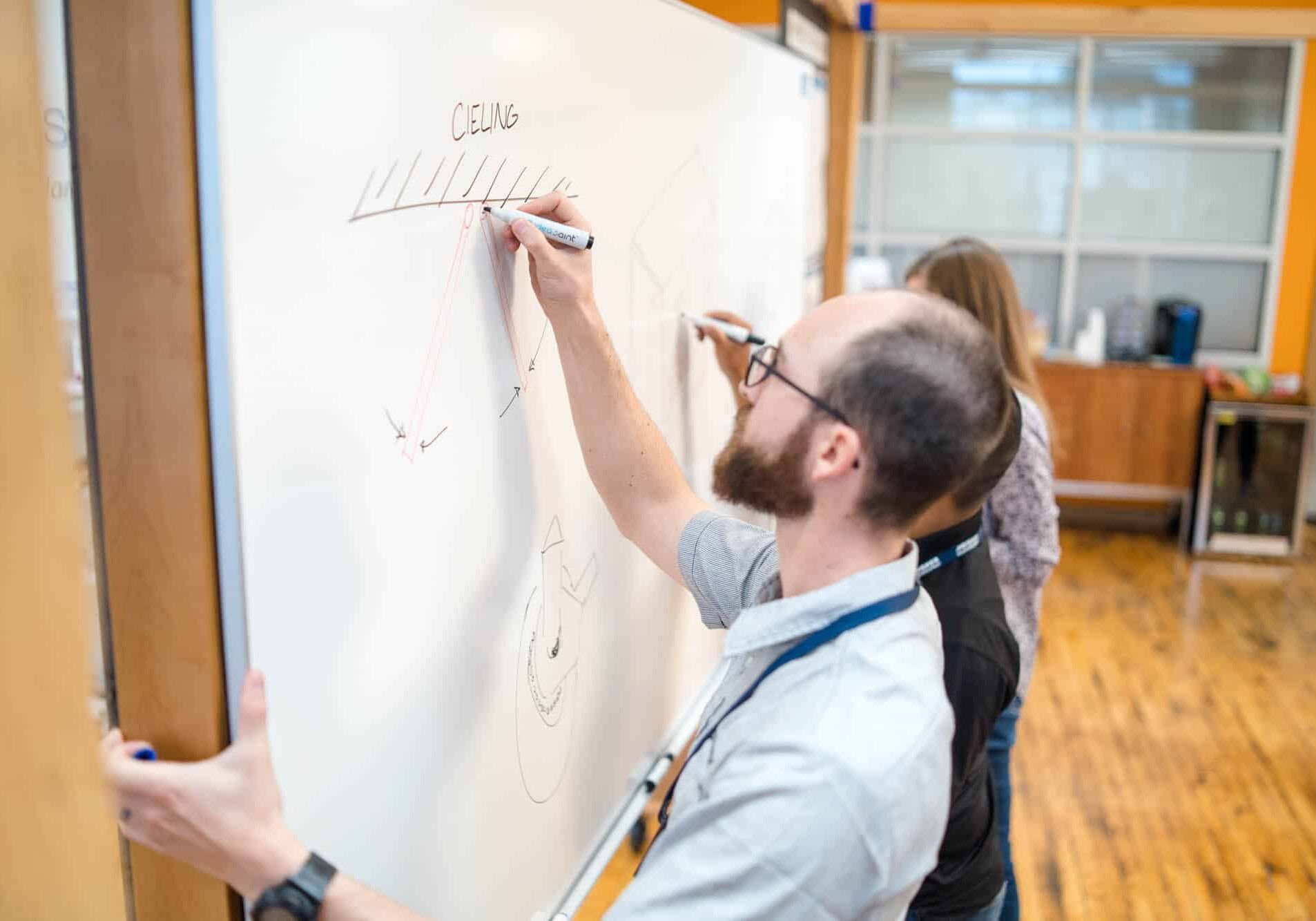 An engineer sketches out ideas on a whiteboard